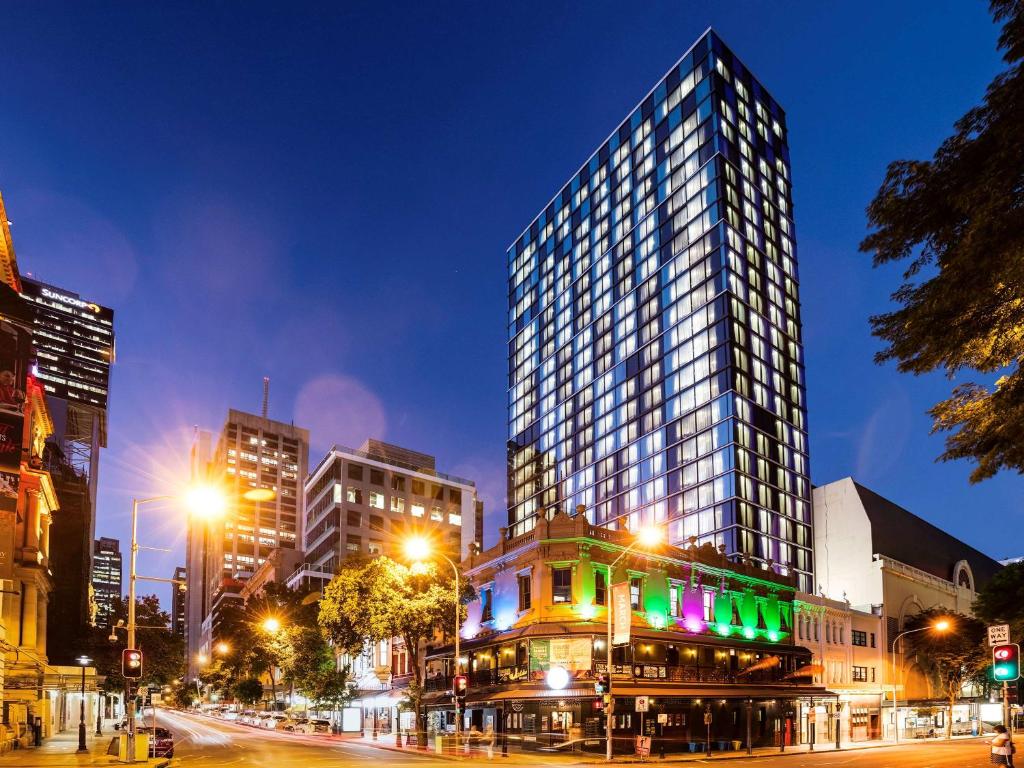 布里斯班ibis Styles Brisbane Elizabeth Street的夜幕降临的城市街道上一座高楼