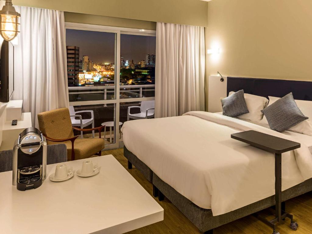 圣贝尔纳多-杜坎普Mercure Sao Bernardo Do Campo的酒店客房设有一张大床和一个阳台。