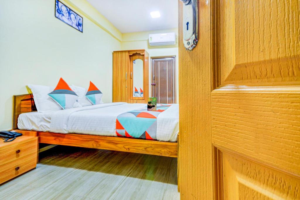哥印拜陀FabExpress Ragu Residency的一间卧室配有一张床和镜子