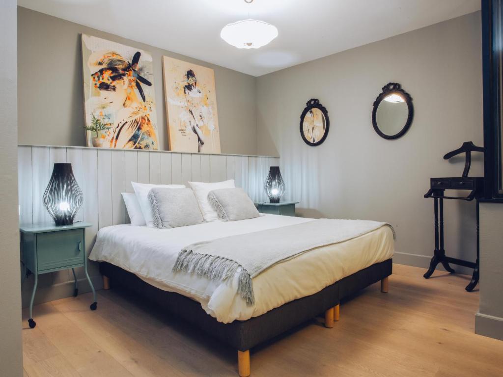 Écurie普拉美&克顿酒店的一间卧室配有一张带两张桌子和两个钟表的床。