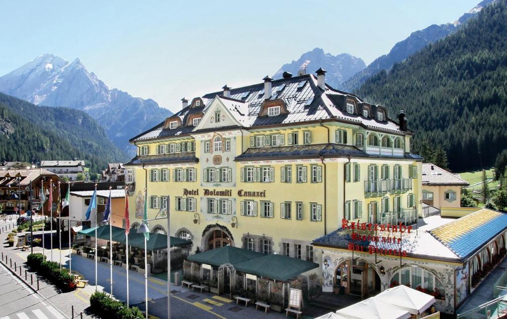 卡纳泽伊Hotel Dolomiti Schloss的一座位于城镇中心的黄色大建筑