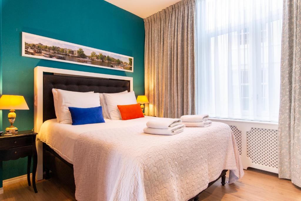 阿姆斯特丹鲜花住宿加早餐旅馆的一间卧室配有带色彩缤纷枕头的床。