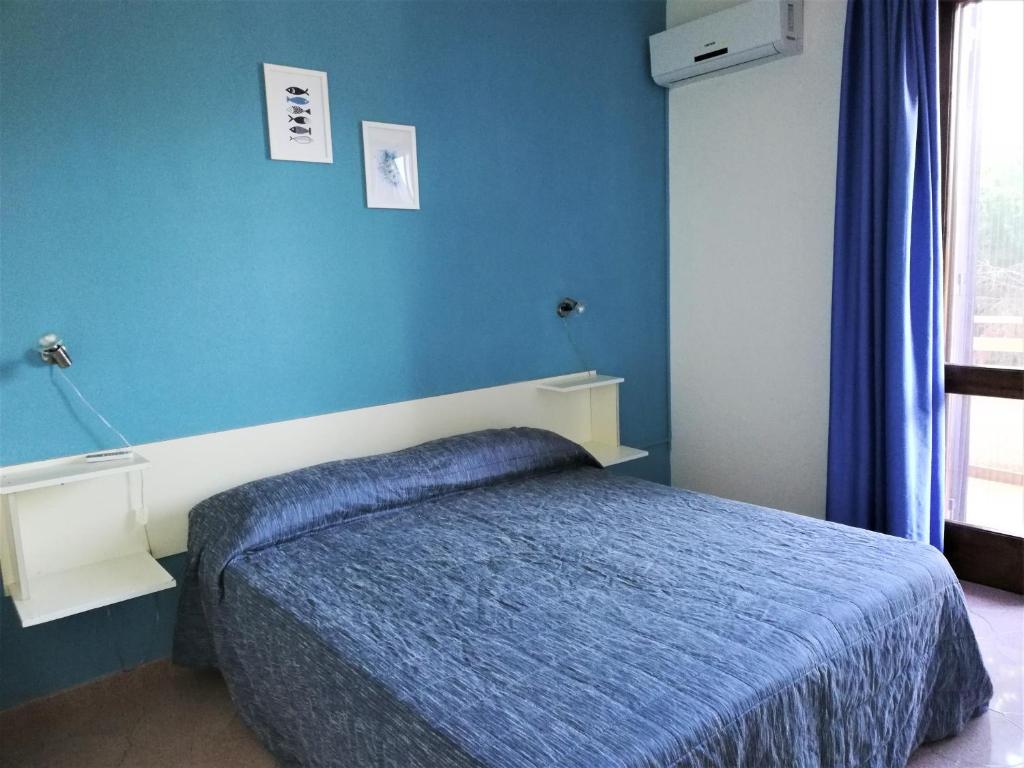 托雷拉皮罗Donna Carmela的一间卧室配有一张蓝色墙壁的床