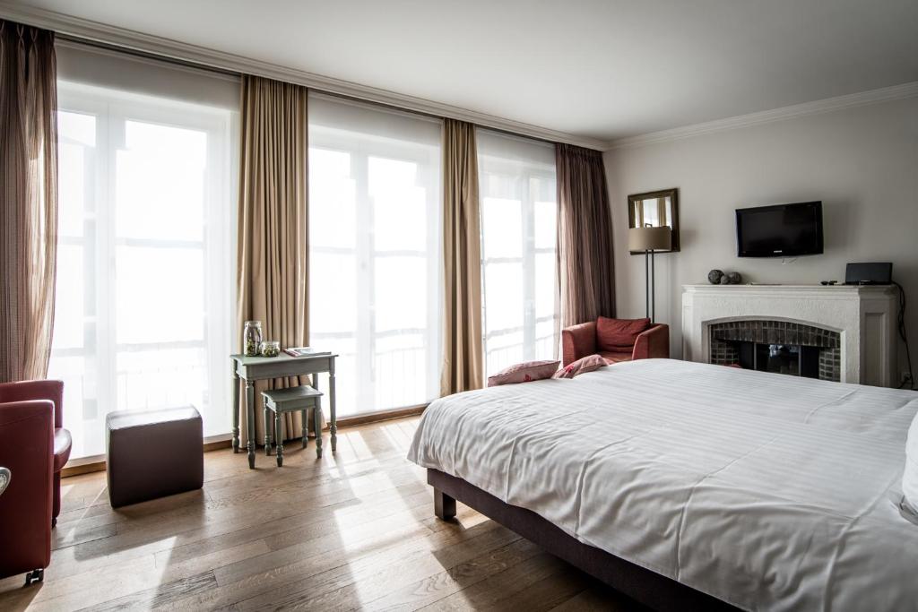波佩林赫Hotel de la Paix的酒店客房配有一张床和一个壁炉。