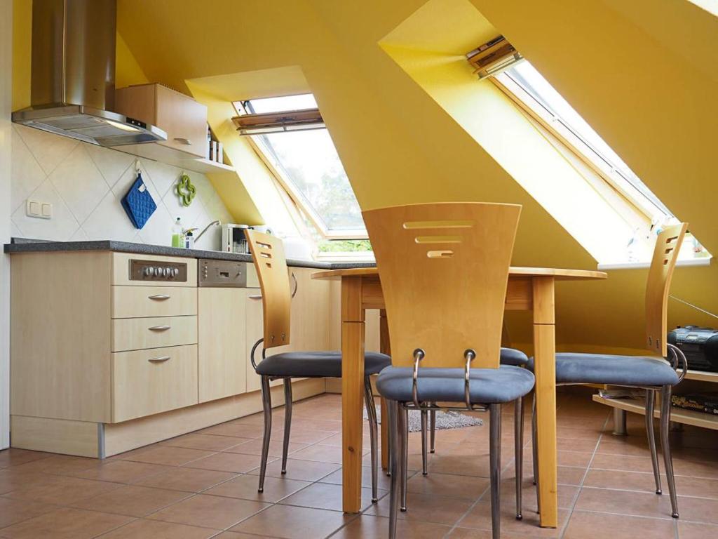 普雷罗Haus am Brunnen Apartment 50的厨房配有桌椅和窗户。