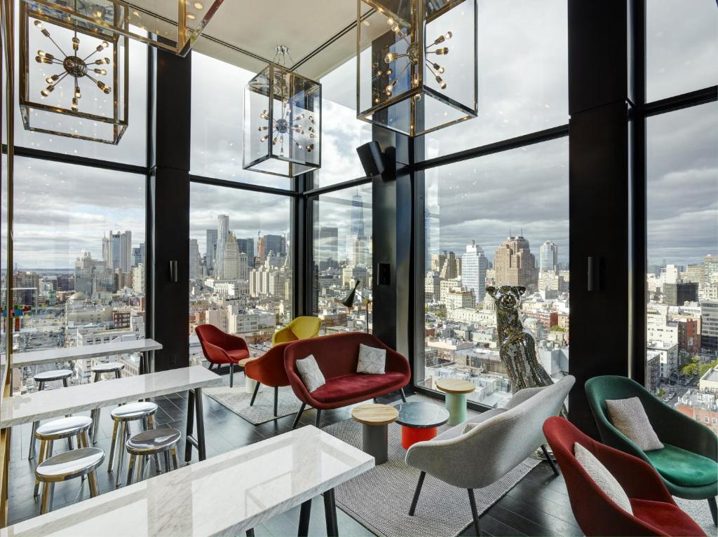 纽约纽约包厘街世民酒店的一间酒吧,配有桌椅,享有城市美景