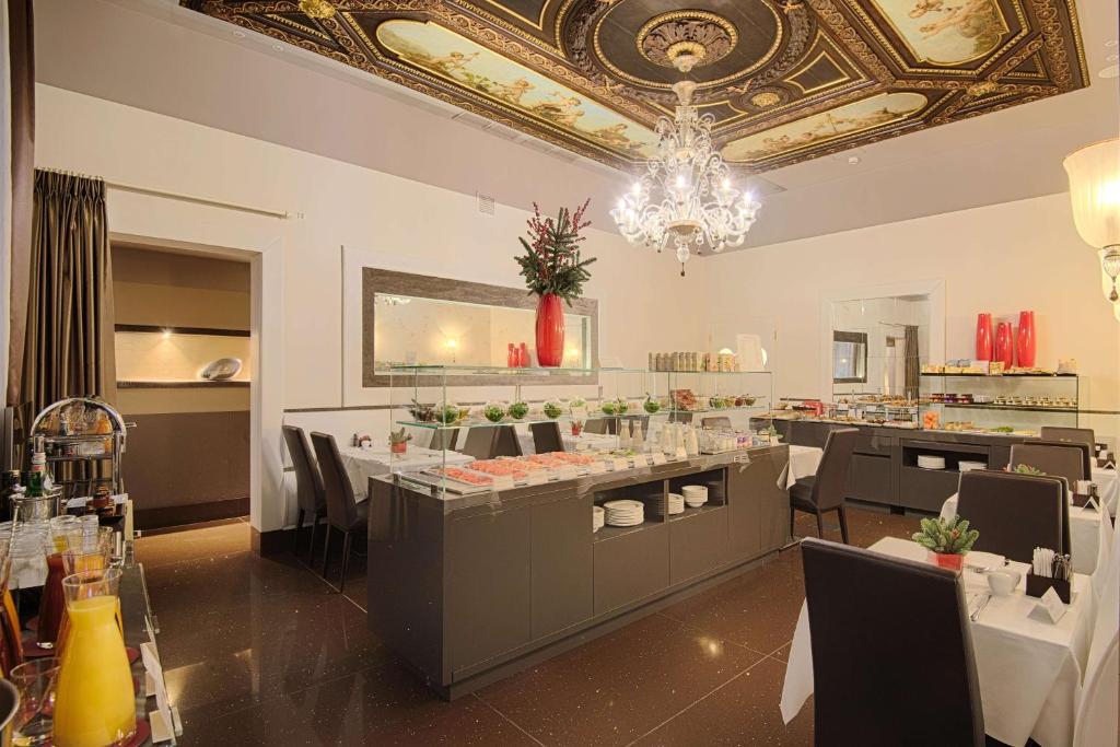 威尼斯Palazzo Barocci的餐厅设有酒吧,配有桌椅