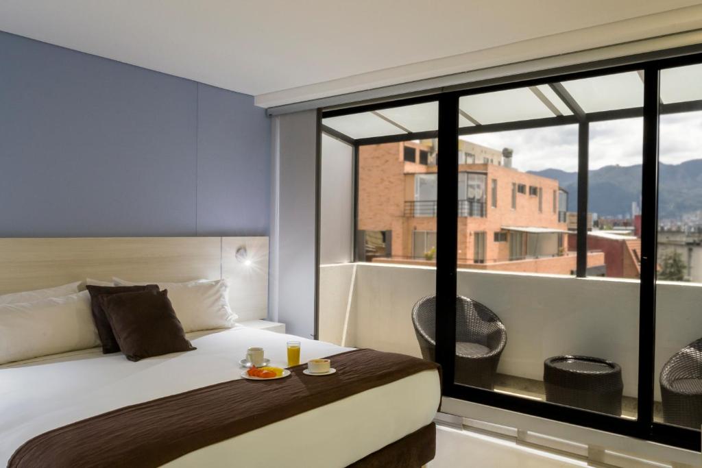 波哥大Hotel Regency Boutique La Feria的一间卧室设有一张床和一个大窗户
