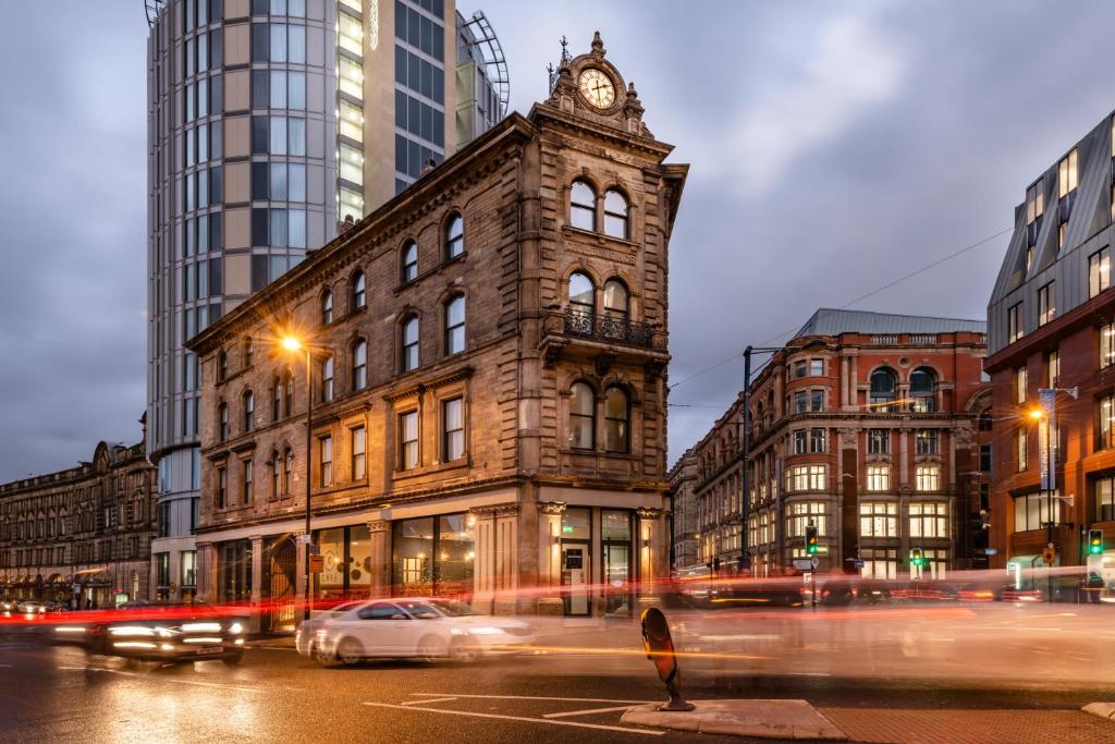 曼彻斯特Hotel Indigo Manchester - Victoria Station, an IHG Hotel的一座城市中带有钟楼建筑