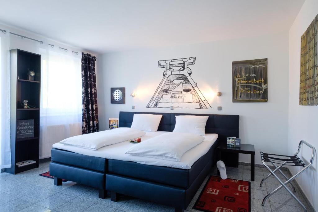 埃森考斯晨艺术酒店的一间卧室配有蓝色的床和白色枕头