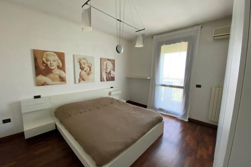 Fiesso dʼArticoAppartamento Girasole tra Padova e Venezia的卧室配有一张墙上挂有照片的床