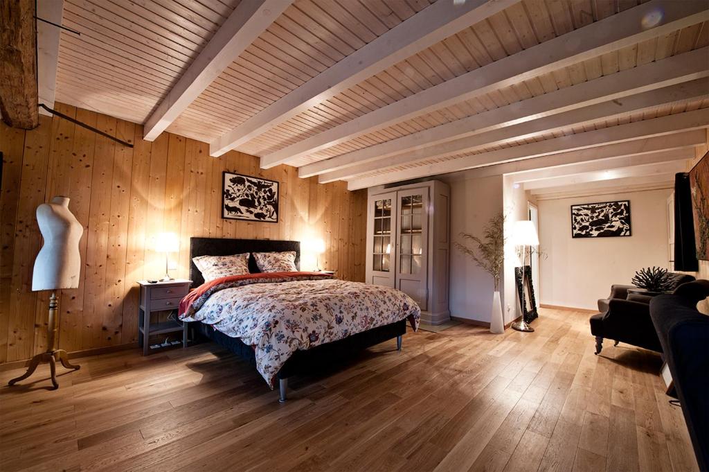 克吕特绿色艺术酒店的一间卧室设有床铺、木墙和木地板