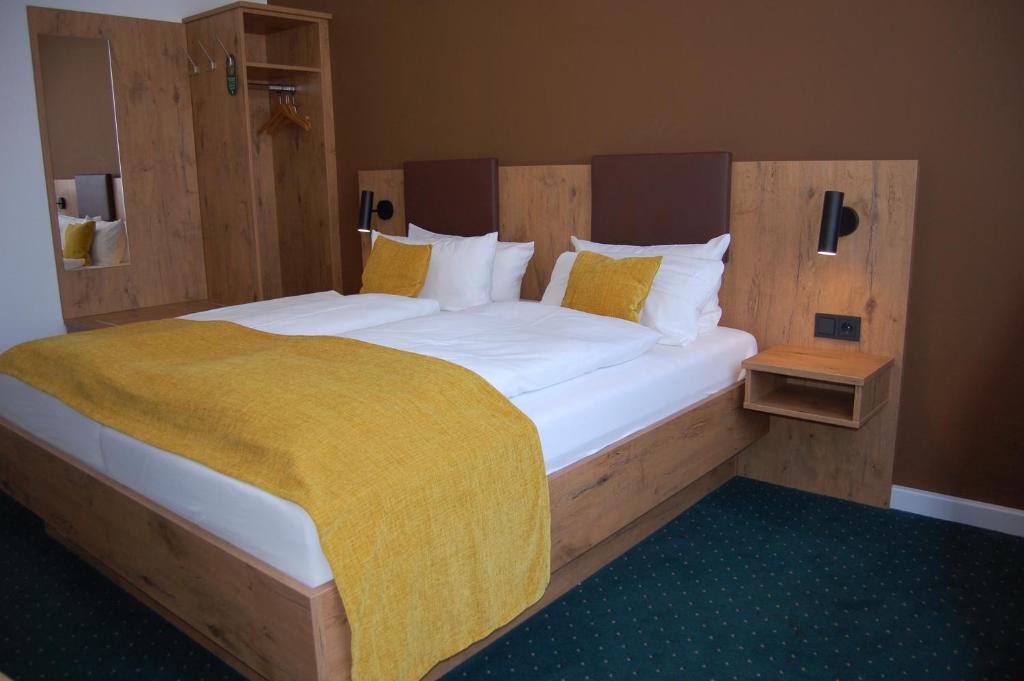 卡尔斯鲁厄埃姆马克特酒店的一间卧室配有一张大床,床上有黄色的毯子