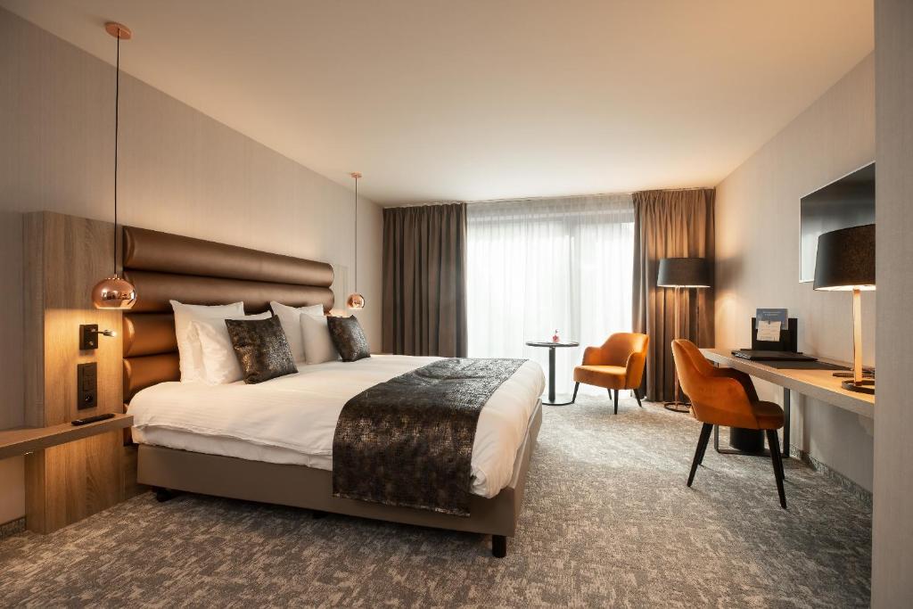 尼韦勒Hotel Restaurant Van Der Valk Nivelles-Sud的配有一张床和一张书桌的酒店客房