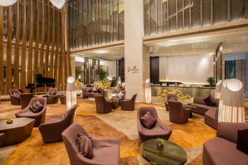 福州福州融侨皇冠假日酒店的大堂配有沙发、椅子和投影屏幕