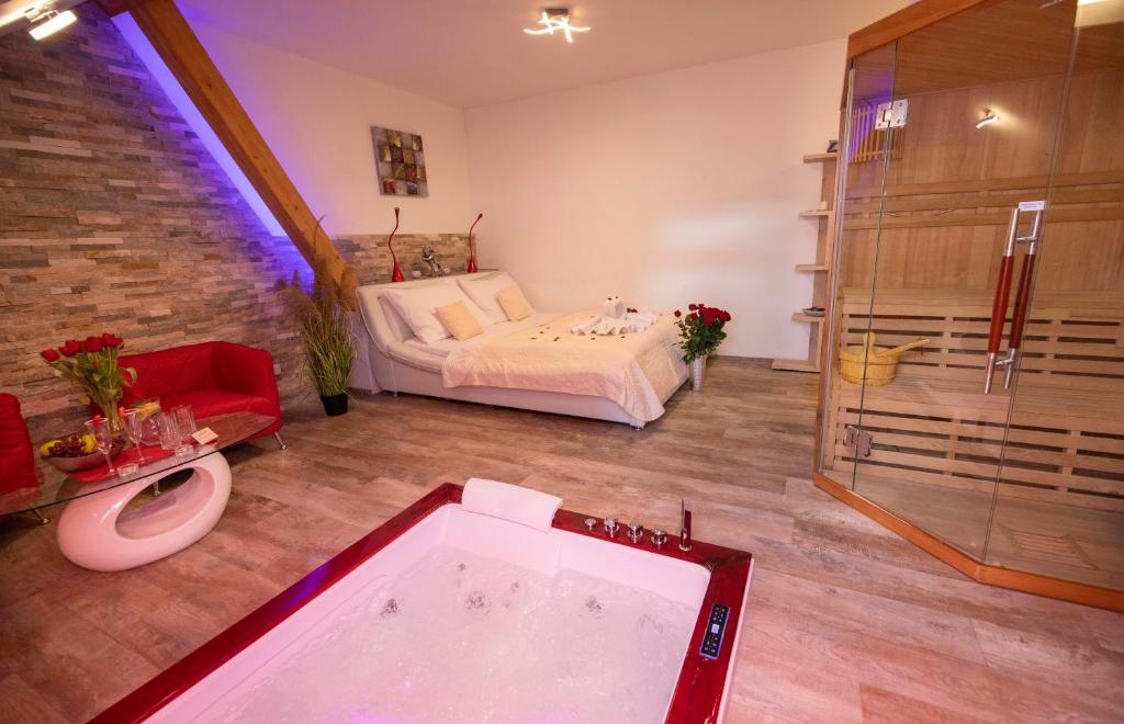 多布日什Romantický wellness suite hotel Heinz的一间带浴缸的浴室和一张位于客房内的床