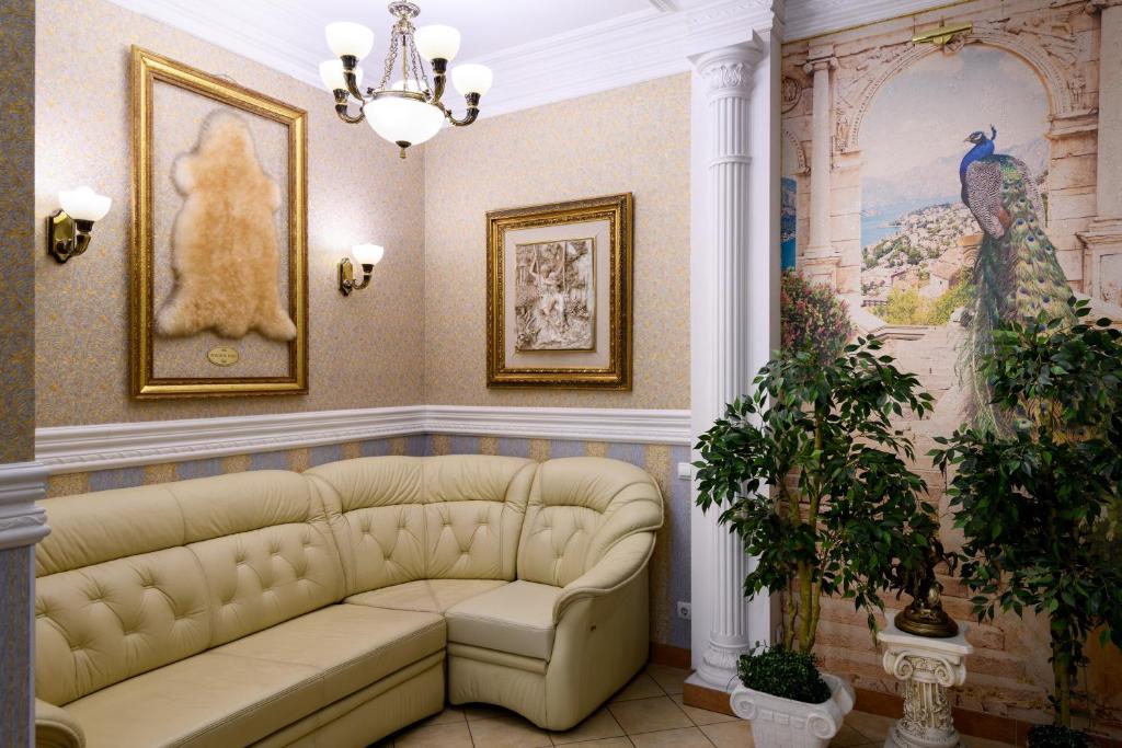 新西伯利亚金羊毛酒店的客厅配有沙发,墙上挂有绘画作品