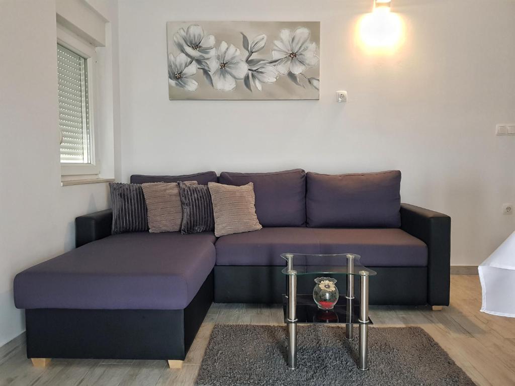Kaštel SućuracApartman Nela的客厅配有紫色沙发和桌子