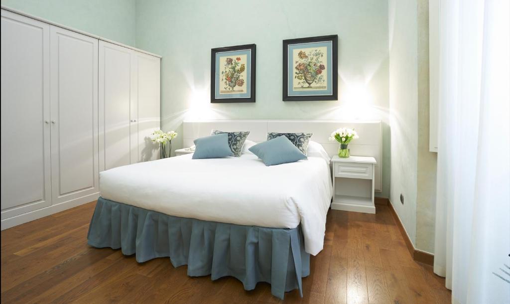 佛罗伦萨拉希诺丽雅迪菲兰其B&B酒店的卧室配有带蓝色枕头的大型白色床