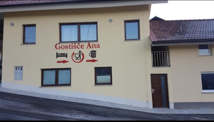 Hrib-Loški PotokHotel and Restaurant Ana的白色的建筑,旁边标有标志