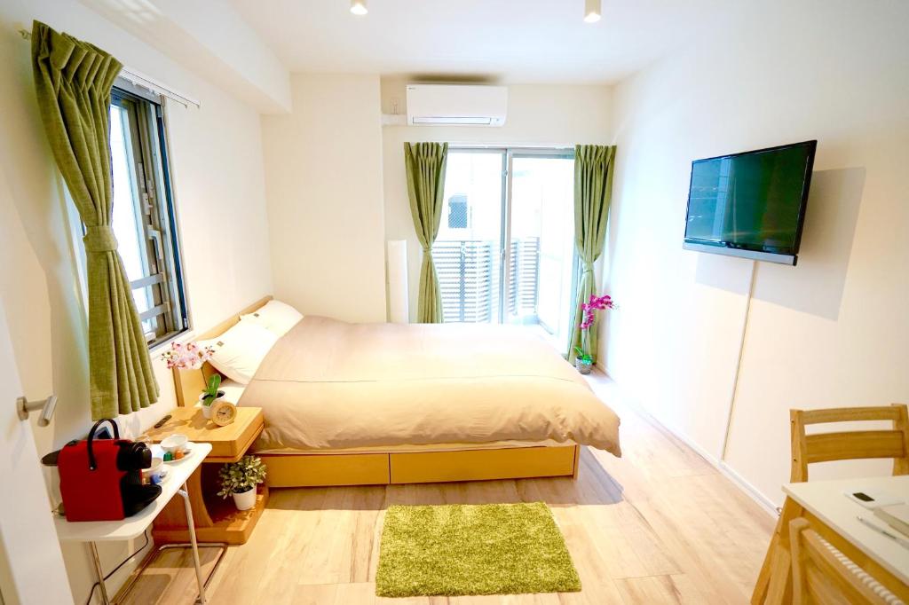 东京Jeffery Skytree Residence Tokyo的一间小卧室,配有一张床和电视
