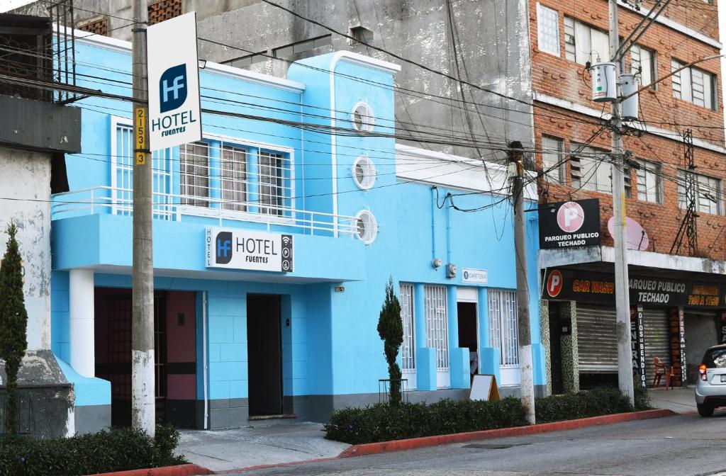 危地马拉Hotel Fuentes的街道边的蓝色建筑