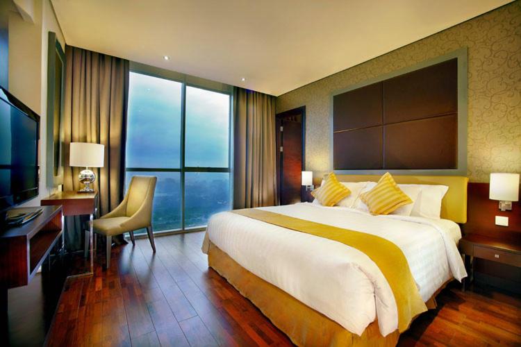 普禾加多ASTON Purwokerto Hotel & Conference Center的酒店客房设有一张大床和一张书桌。
