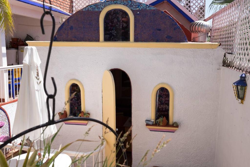 提华纳Greek Cottage Playas de Tijuana的一间玩具屋,房子的一侧有三个窗户