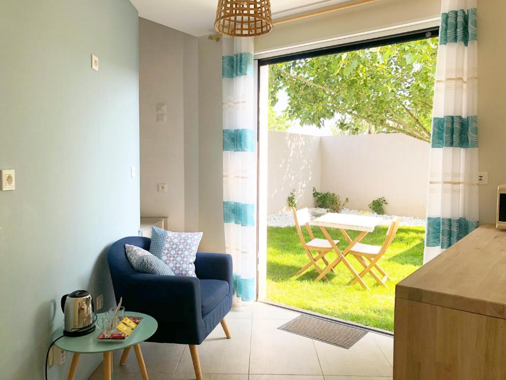 莱萨布勒-多洛讷Estrella的客厅配有蓝色椅子和滑动玻璃门