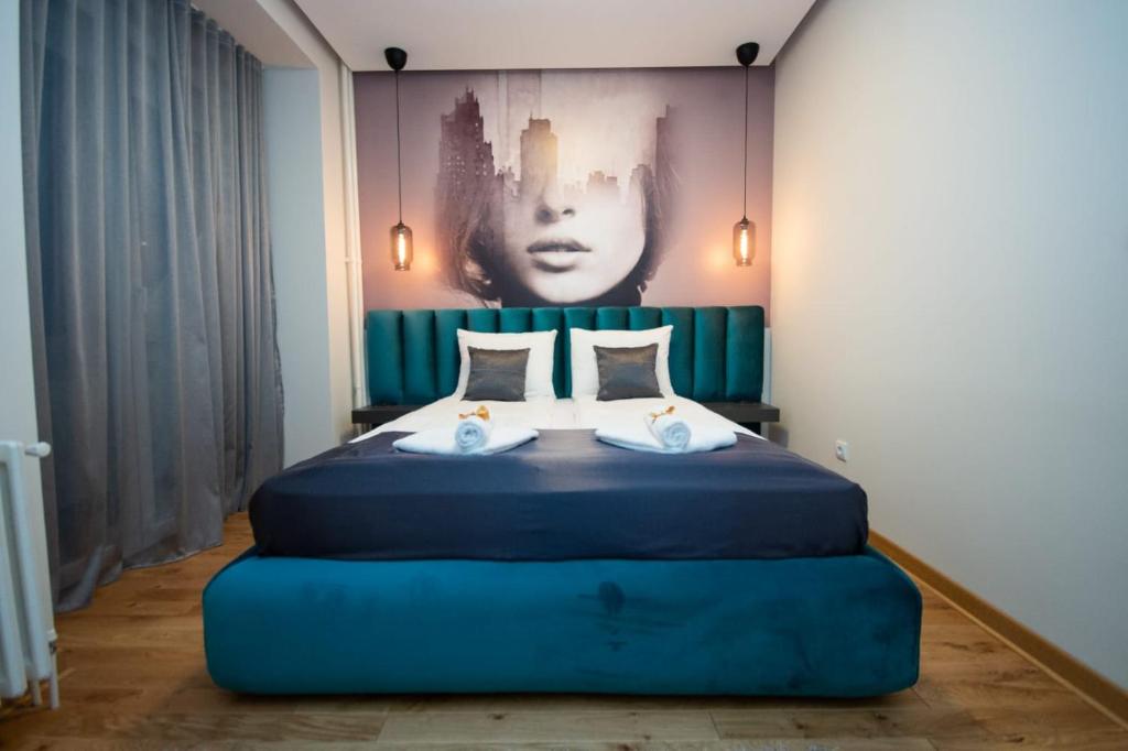 贝尔格莱德Belgrade CITY CENTER Apartments的卧室配有一张蓝色的床,墙上挂着一幅画