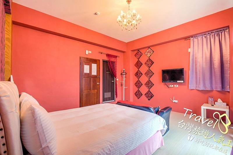 台东时尚玩家民宿的一间卧室拥有橙色的墙壁和一张大床