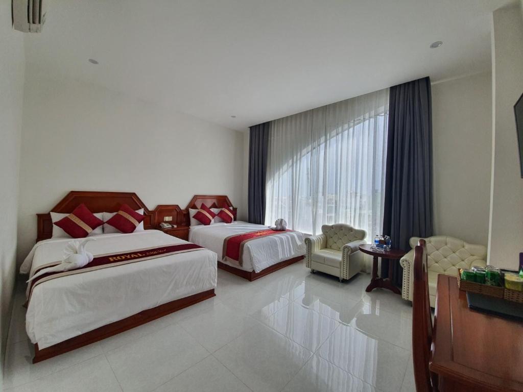 Bạc LiêuRoyal Hotel的酒店客房设有两张床和窗户。