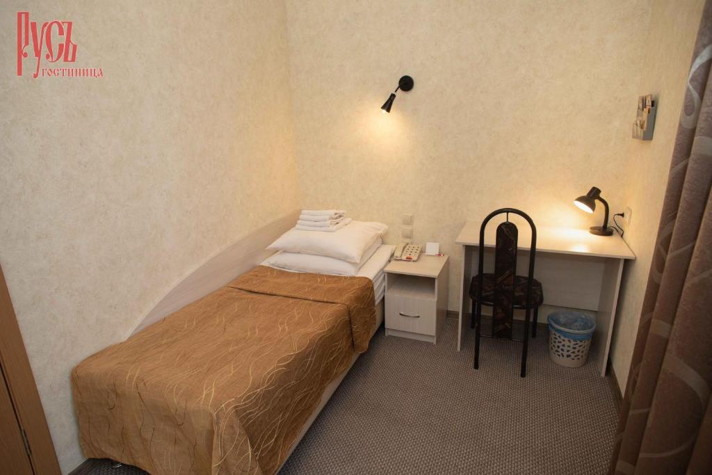 巴尔瑙尔鲁斯酒店的一间小卧室,配有一张床和一张书桌