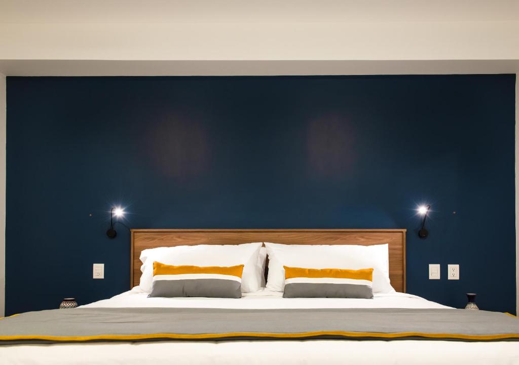 墨西哥城Hotel Boutique Parque Centro的一间卧室设有一张蓝色墙壁的大床