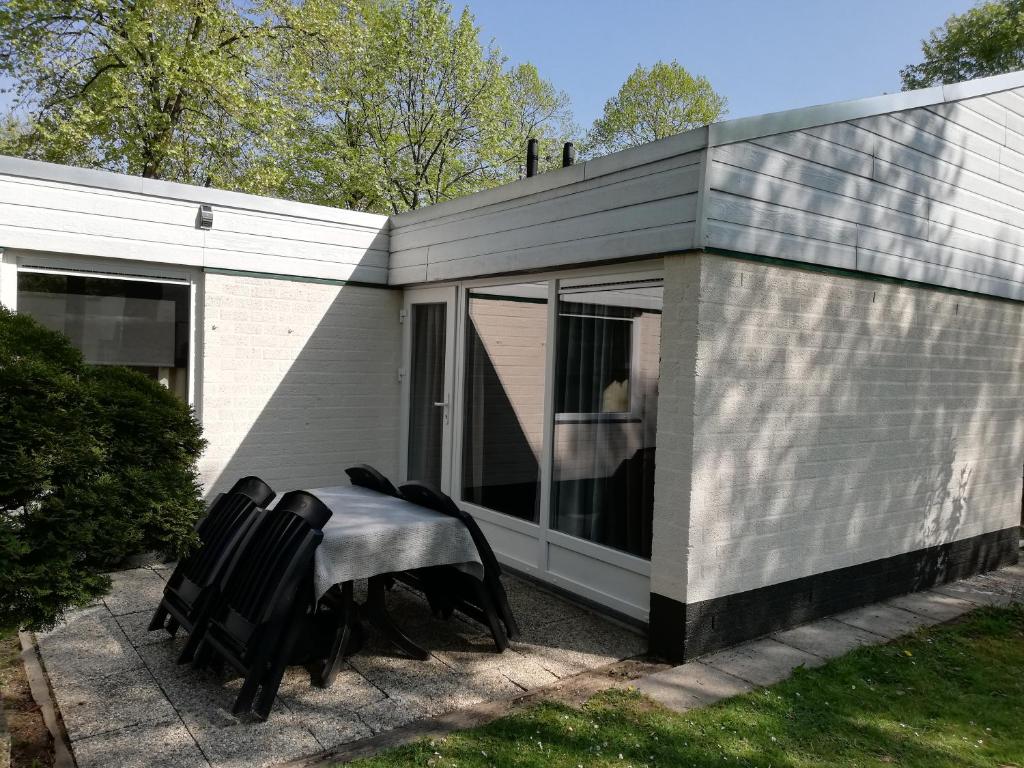 辛佩尔费尔德Rustige, gelijkvloerse vakantiewoning met 2 slaapkamers in Simpelveld, Zuid-Limburg的前面的小房子,配有桌椅