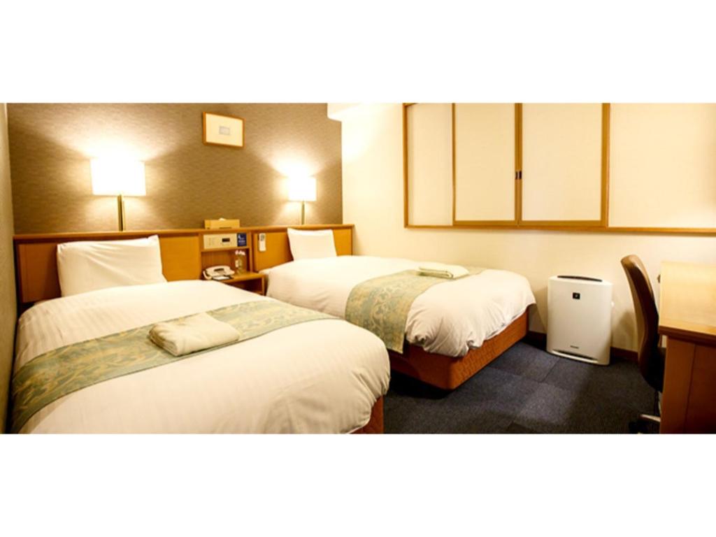 福冈Hakata Floral Inn Nakasu / Vacation STAY 80214的一间酒店客房,房间内设有两张床