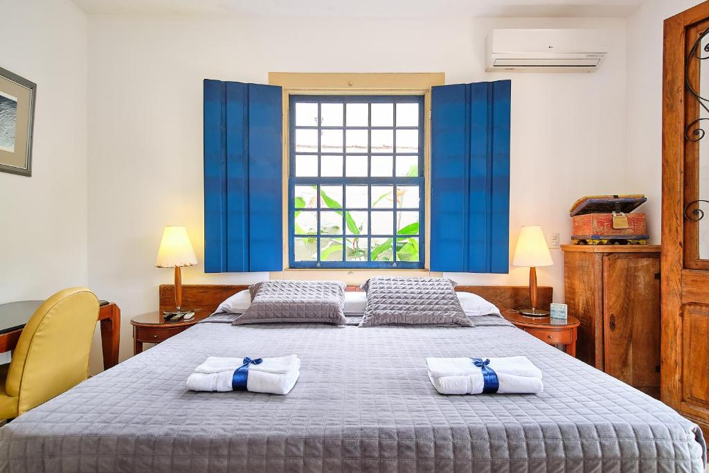 帕拉蒂蓬塔尔花园旅馆的一间卧室配有一张大床和毛巾