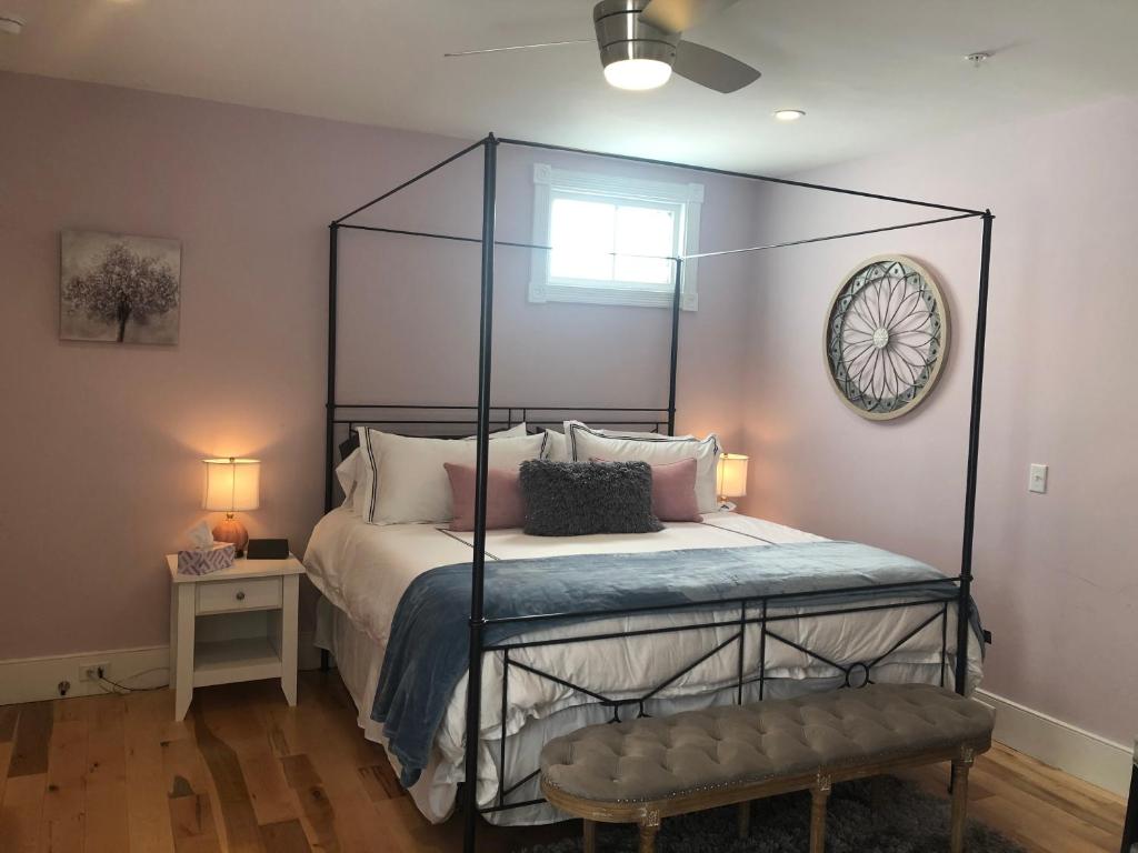 查尔斯顿Luxurious Private Suites in Downtown Charleston的一间卧室配有一张黑色天蓬床和长凳