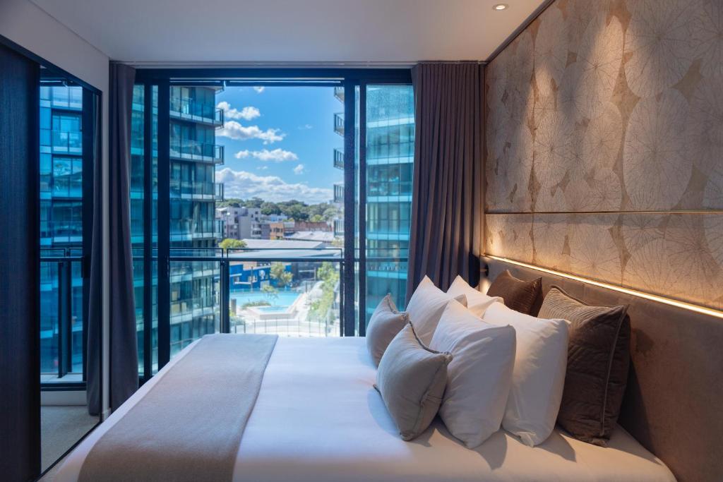 悉尼SKYE Suites Green Square的一间卧室设有一张大床和大窗户