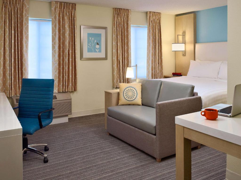 伯灵顿波士顿伯灵顿ES套房圣淘沙集团酒店的酒店客房配有床、沙发和椅子
