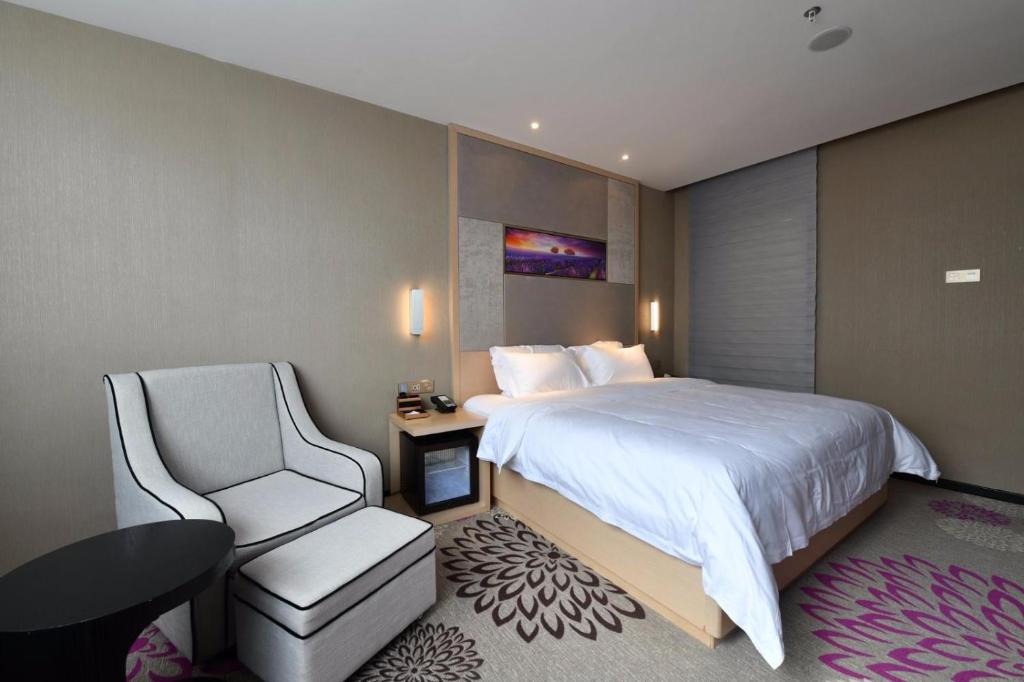 惠州麗枫酒店·惠州高铁南站万联广场店的配有一张床和一把椅子的酒店客房