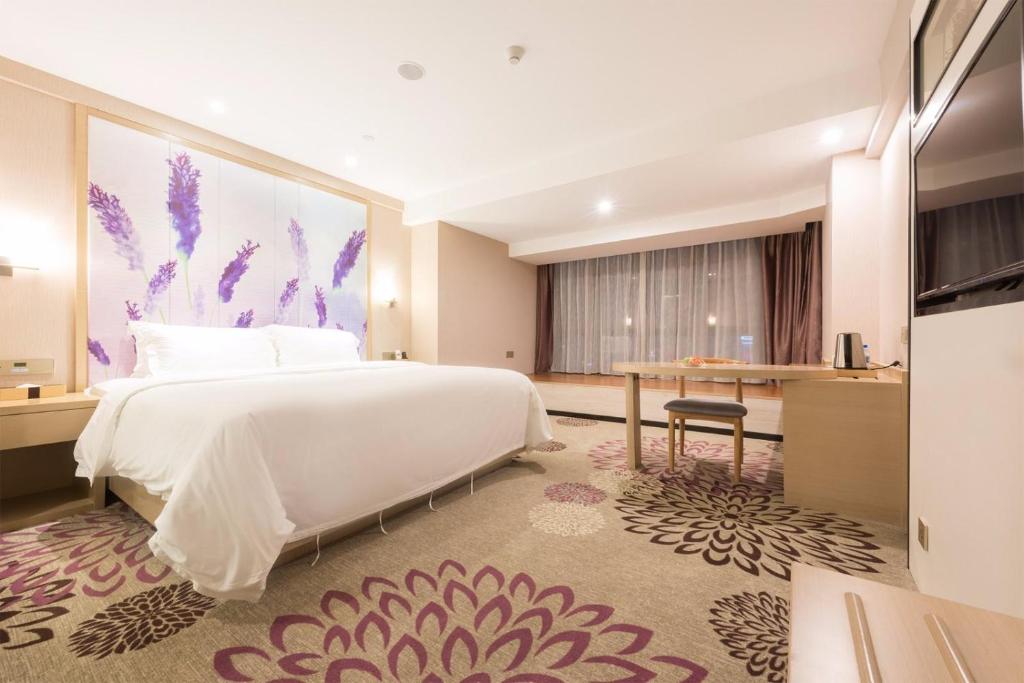 河源麗枫酒店·河源万隆城店的卧室配有一张白色大床和一张书桌
