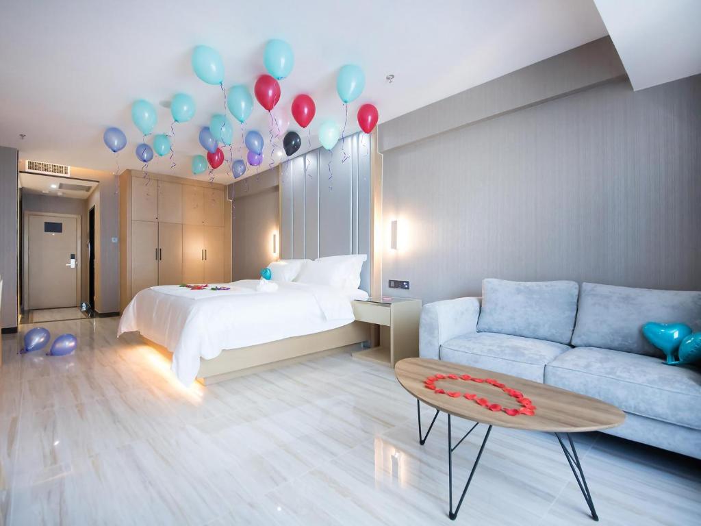 乌鲁木齐麗枫酒店·乌鲁木齐高铁万达广场店的一间设有一张床、气球和一张沙发的房间
