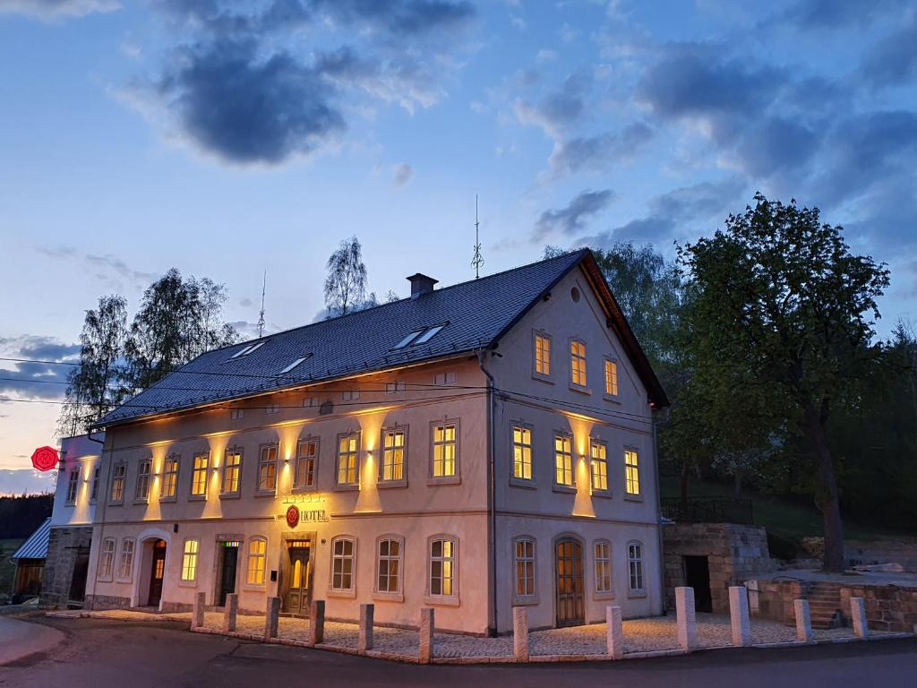 耶什赫维采Hotel KORTUS的一座白色的大建筑,灯火通明