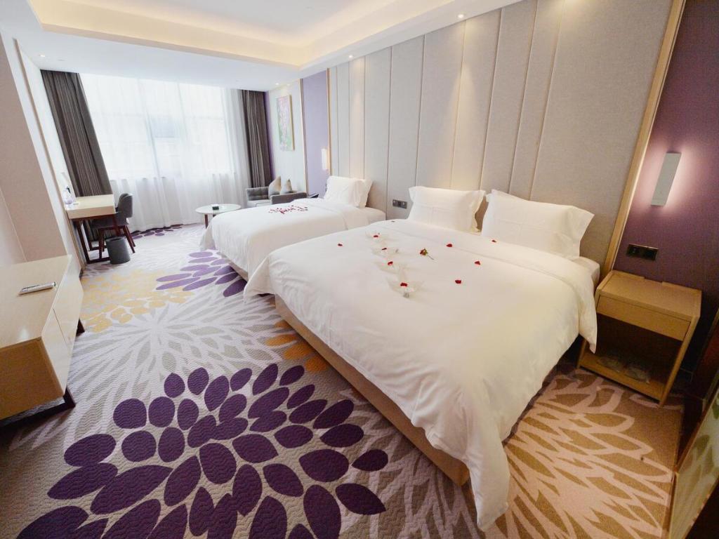 下午屯麗枫酒店·兴义桔山大道店的酒店客房,配有两张带鲜花的床