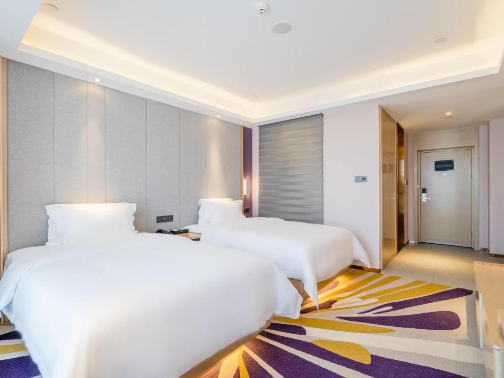 泸州麗枫酒店·泸州万达广场西南商贸城店的一间酒店客房,设有两张床和走廊