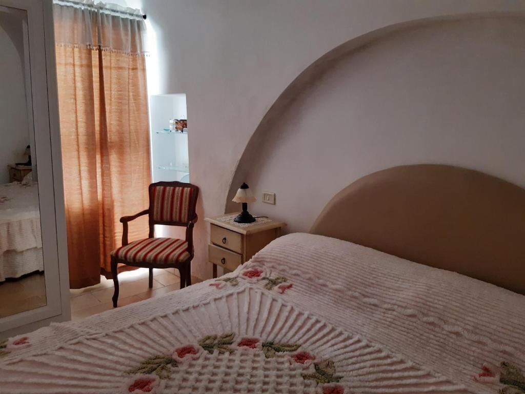 法萨诺appartamento butterfly的卧室配有床、椅子和窗户。