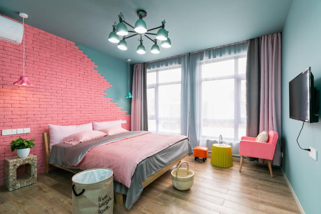 上海上海80逅创意民宿的卧室设有砖墙和粉红色的床