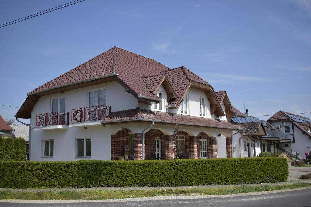 NagypáliFőnix Apartmanház的白色房子,有棕色的屋顶
