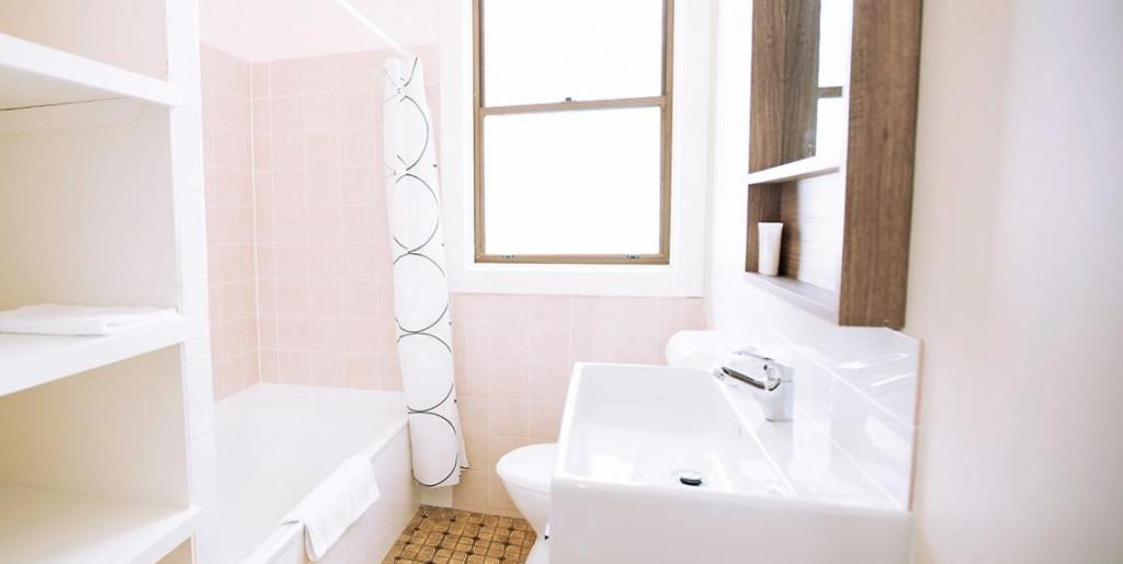 拜伦湾木槿汽车旅馆 的一间带水槽和卫生间的浴室以及窗户。